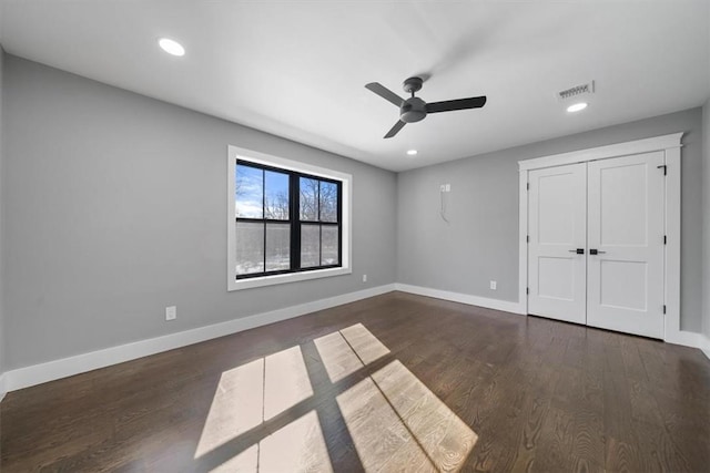 unfurnished bedroom featuring ceiling fan, dark wood-type flooring, and a closet