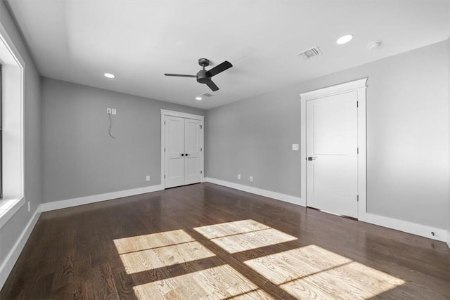 empty room with ceiling fan and dark wood-type flooring