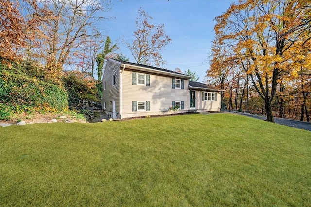 rear view of house featuring a lawn