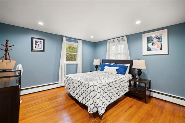 bedroom with a baseboard radiator and hardwood / wood-style flooring