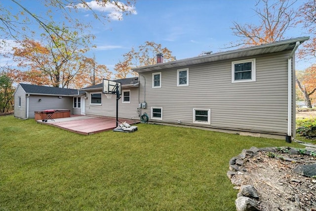 back of property with a lawn, a hot tub, and a deck