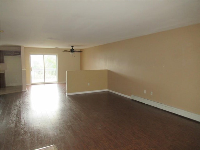 spare room featuring baseboard heating, ceiling fan, and dark wood-type flooring