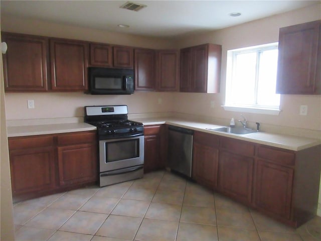 kitchen with light tile patterned floors, stainless steel appliances, and sink