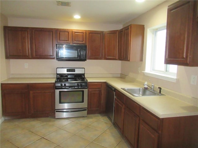 kitchen featuring light tile patterned floors, stainless steel appliances, and sink