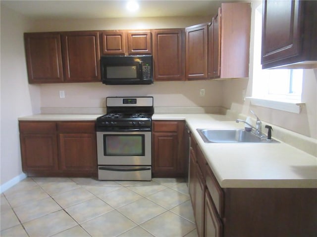 kitchen featuring light tile patterned floors, sink, and stainless steel range with gas stovetop