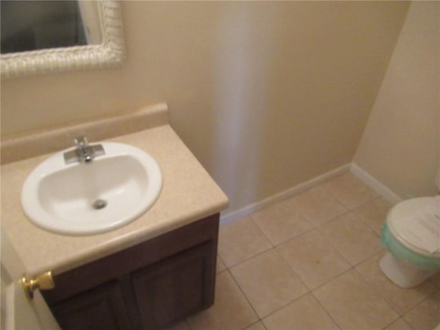 bathroom with tile patterned flooring, vanity, and toilet