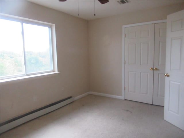 unfurnished room featuring ceiling fan, light colored carpet, and baseboard heating