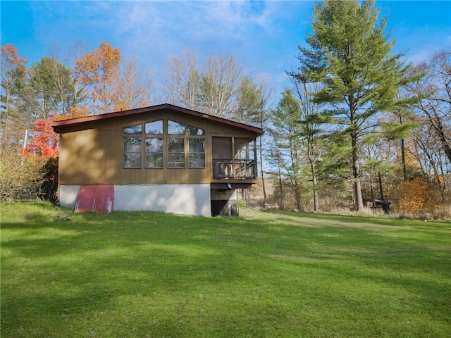 view of side of home featuring a sunroom and a lawn