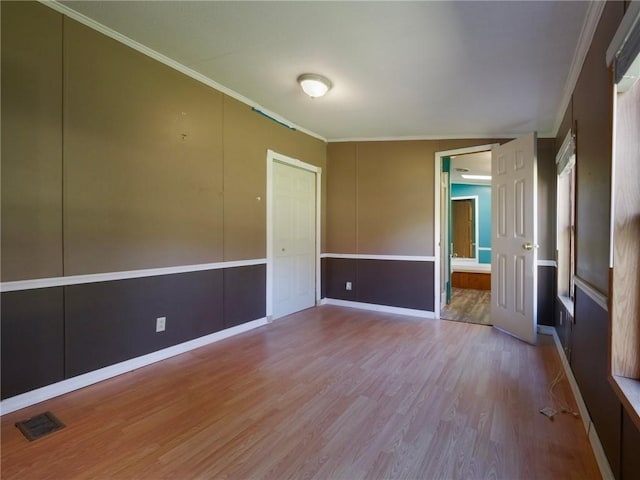 unfurnished room featuring ornamental molding and light wood-type flooring