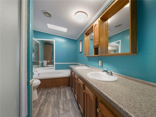 bathroom with lofted ceiling with skylight, crown molding, hardwood / wood-style flooring, a washtub, and toilet