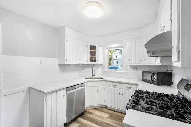 kitchen featuring dishwasher, gas stove, white cabinets, and sink