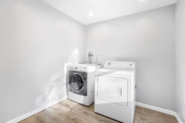 clothes washing area featuring light wood-type flooring and independent washer and dryer