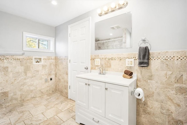 bathroom with vanity and tile walls