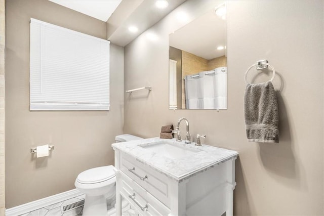 bathroom featuring vanity, toilet, and walk in shower