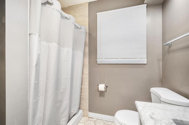 bathroom with tile patterned floors, curtained shower, vanity, and toilet