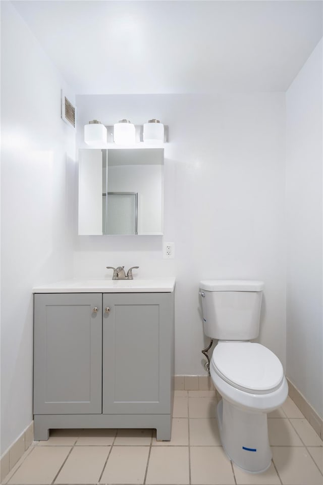 bathroom with tile patterned flooring, vanity, and toilet