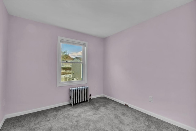 unfurnished room with radiator and light colored carpet