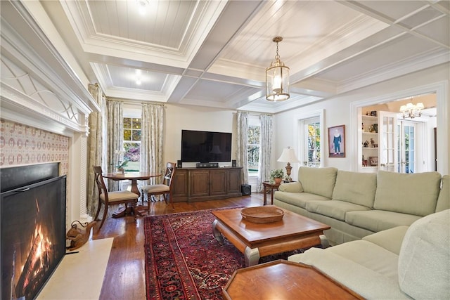 living room featuring a chandelier, plenty of natural light, dark wood-type flooring, and coffered ceiling