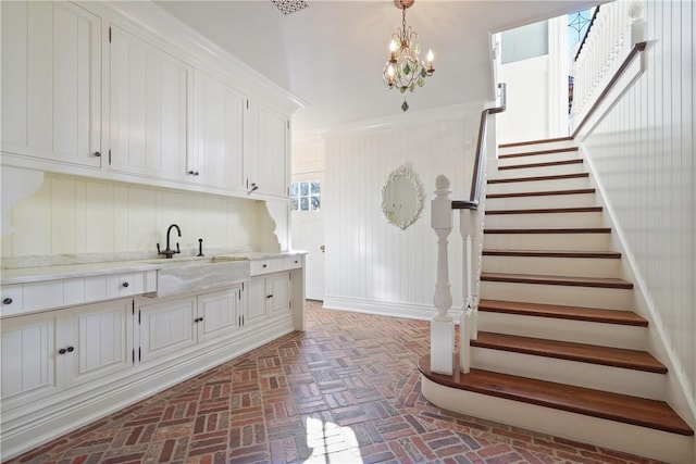 interior space with white cabinets, decorative light fixtures, and sink