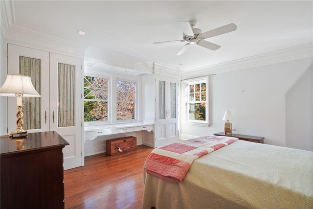 bedroom with hardwood / wood-style flooring, ceiling fan, and ornamental molding