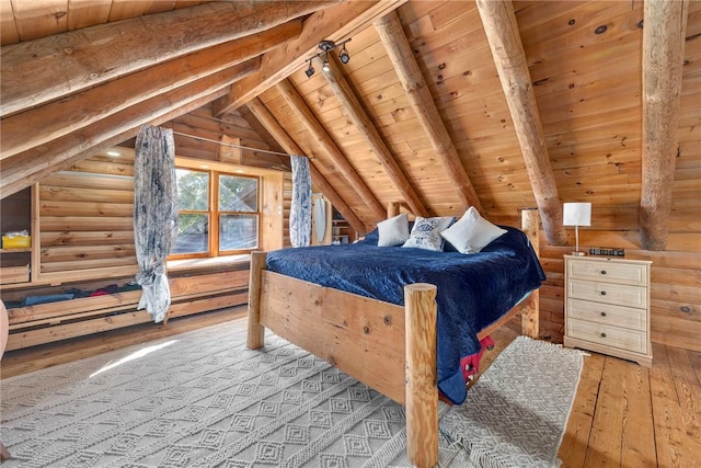 bedroom featuring lofted ceiling with beams, rail lighting, light hardwood / wood-style flooring, rustic walls, and wood ceiling