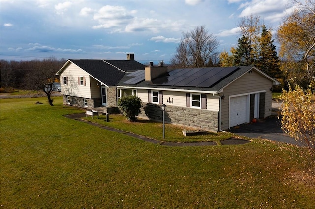 view of front of home featuring solar panels, a garage, and a front lawn