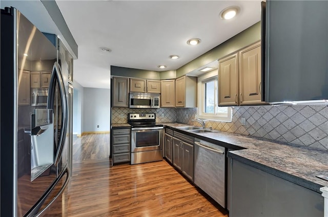 kitchen with decorative backsplash, light wood-type flooring, gray cabinetry, stainless steel appliances, and sink