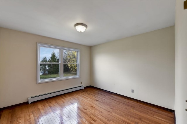 spare room with a baseboard radiator and light hardwood / wood-style flooring