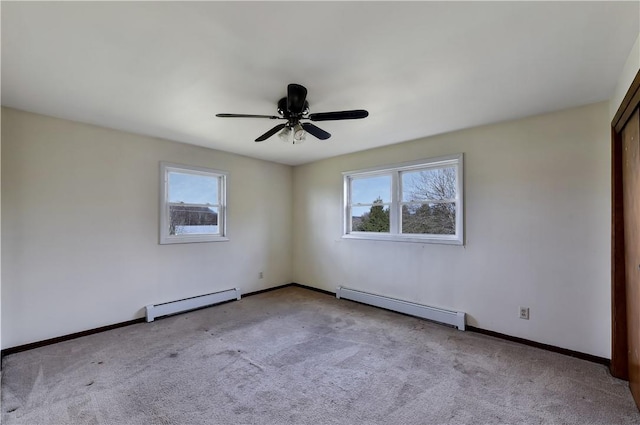 unfurnished room with light carpet, a wealth of natural light, and a baseboard heating unit