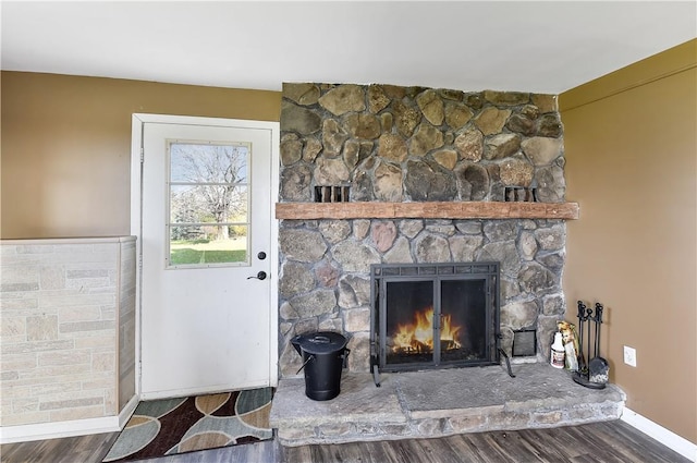 details featuring hardwood / wood-style floors and a stone fireplace