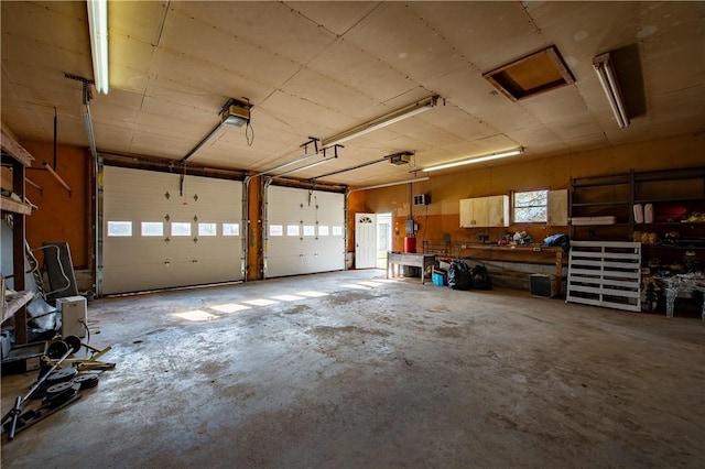 garage with a workshop area and a garage door opener