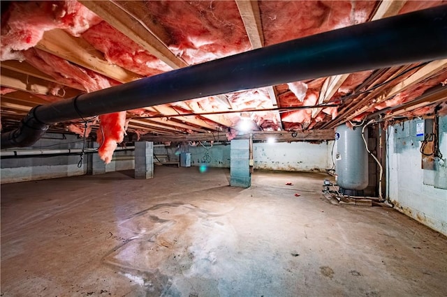 basement featuring electric water heater and water heater