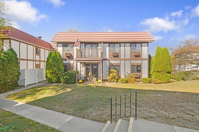 view of front of home with a front yard and a balcony