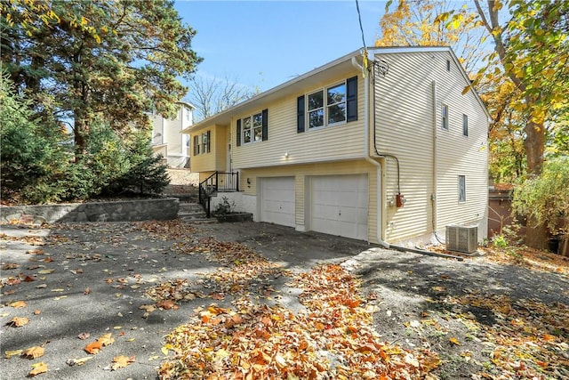 view of side of property featuring a garage and cooling unit