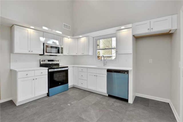 2 Requa St, Briarcliff Manor, NY 10510 - kitchen featuring stainless steel appliances, a sink, white cabinets, light countertops, and a high ceiling