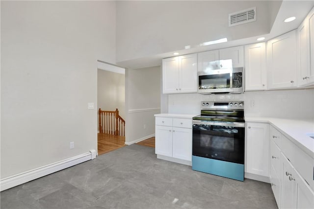 2 Requa St, Briarcliff Manor, NY 10510 - kitchen with appliances with stainless steel finishes, light countertops, a towering ceiling, white cabinetry, and a baseboard heating unit