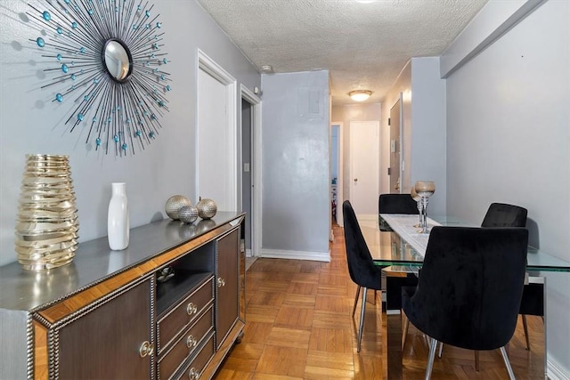 dining area featuring a textured ceiling and light parquet floors