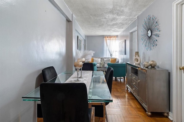 dining room featuring light parquet flooring and a textured ceiling