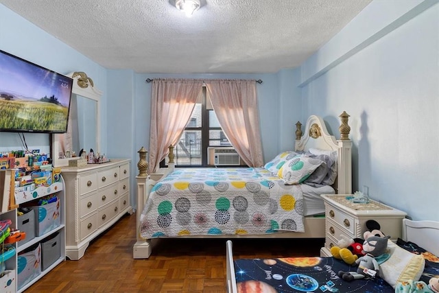 bedroom with dark parquet floors, cooling unit, and a textured ceiling