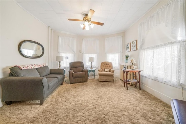 carpeted living room with ceiling fan and crown molding