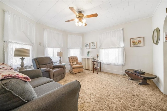 living room featuring carpet, ceiling fan, a healthy amount of sunlight, and radiator