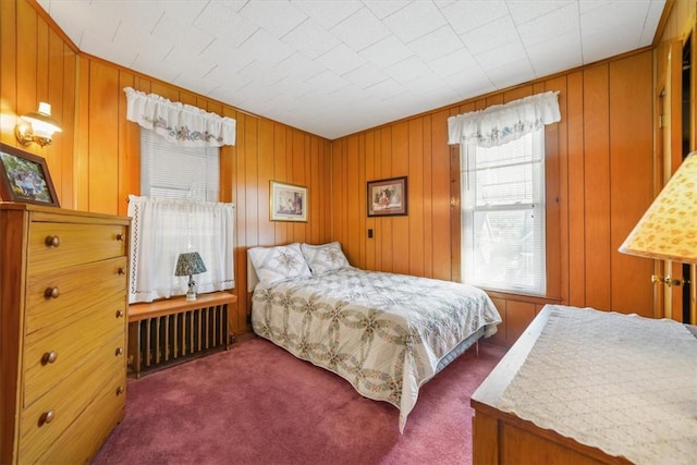 carpeted bedroom with wood walls