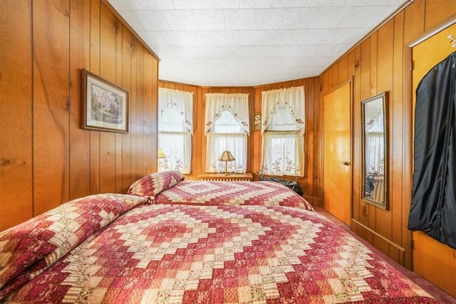 bedroom featuring wood walls