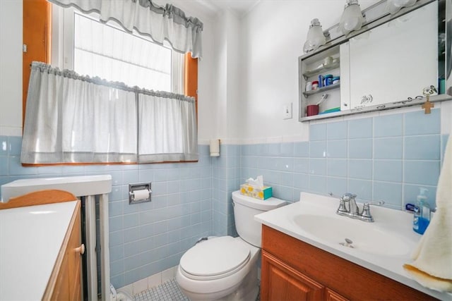 bathroom featuring tile patterned floors, vanity, toilet, and tile walls