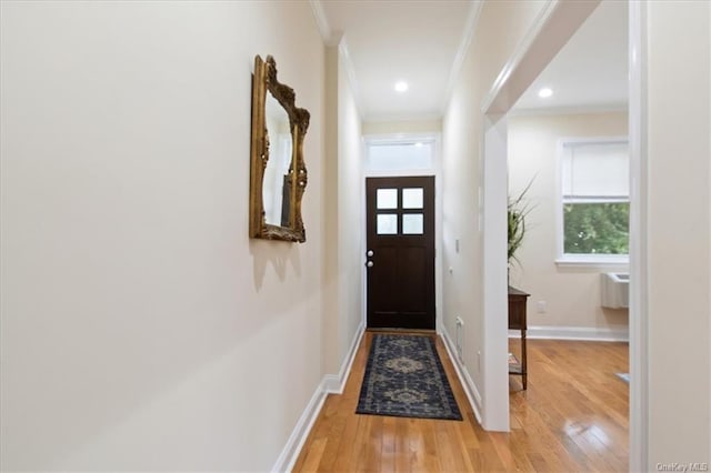 entryway with hardwood / wood-style floors and crown molding