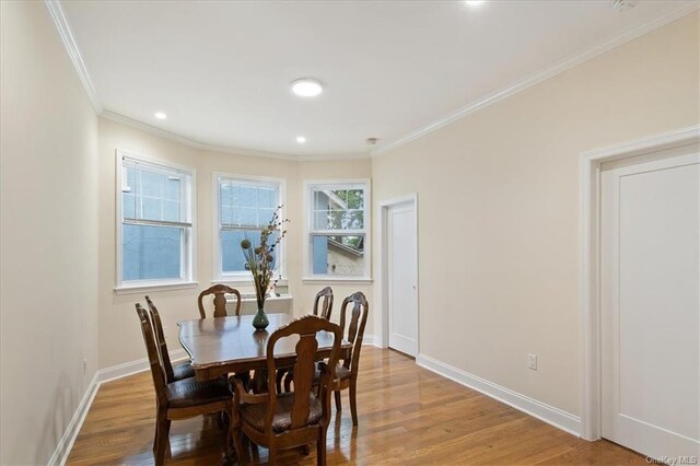 dining area with light hardwood / wood-style floors and crown molding