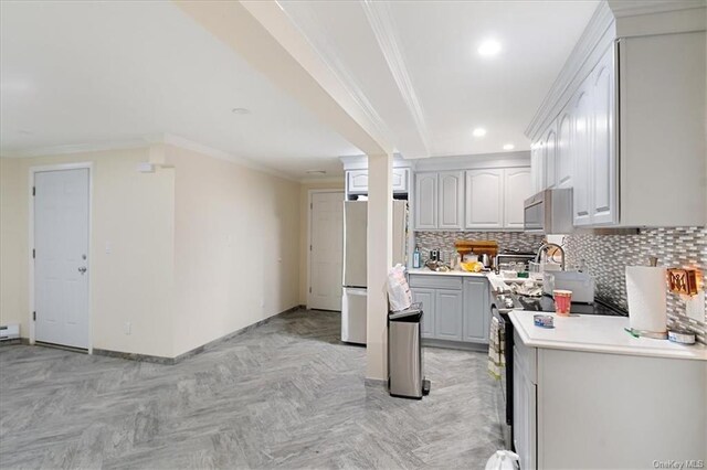 kitchen featuring gray cabinetry, crown molding, light parquet floors, decorative backsplash, and appliances with stainless steel finishes