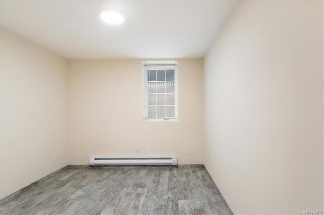 empty room featuring light hardwood / wood-style floors and baseboard heating