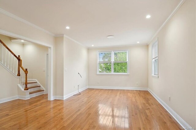 empty room with light wood-type flooring and crown molding