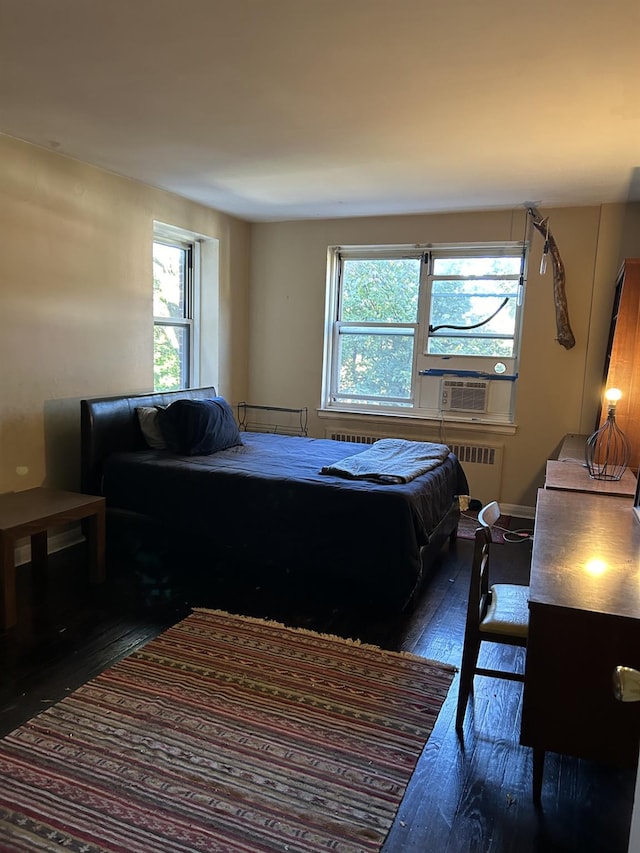 bedroom with radiator, cooling unit, and dark hardwood / wood-style flooring